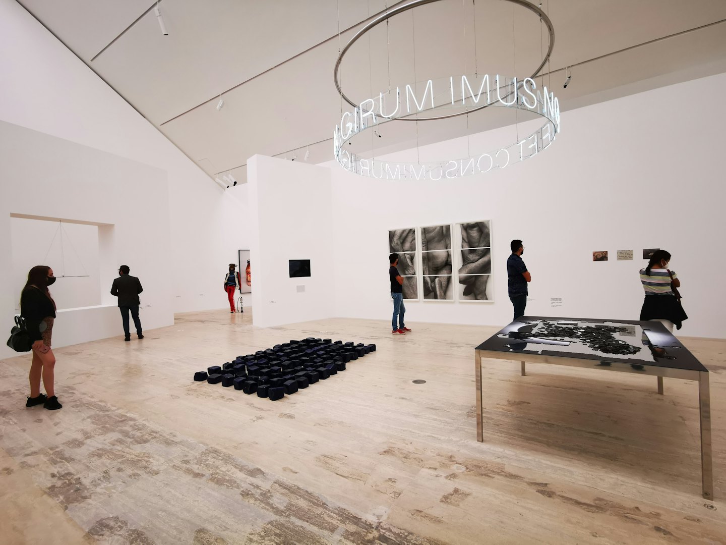 Visitatori passeggiano in una galleria ammirando opere d'arte contemporanea e sculture.