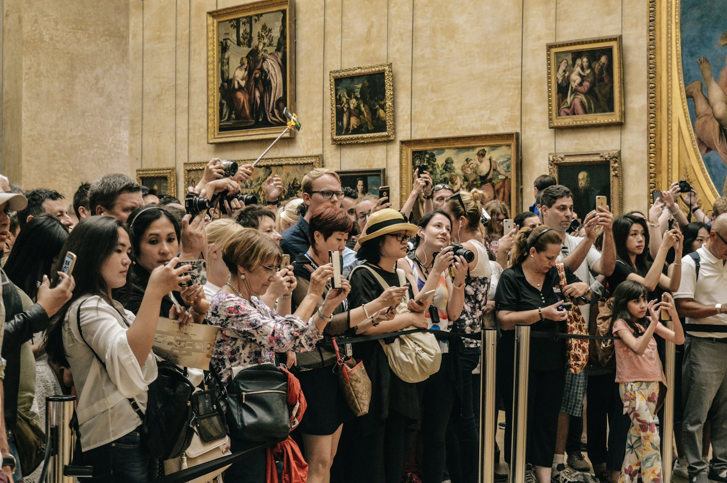 Persone fotografano dipinti classici in una galleria di un museo d'arte.
